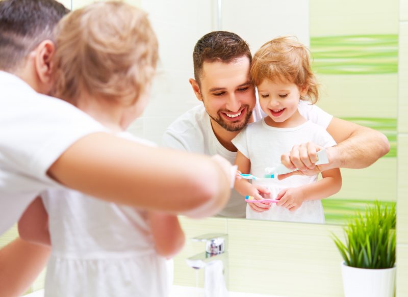 Father and Daughter Brushing Teeth